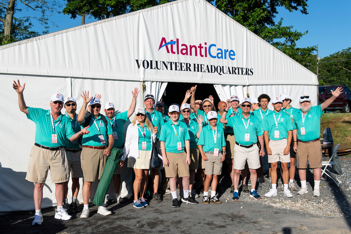 group of volunteers in front of sponsor tent